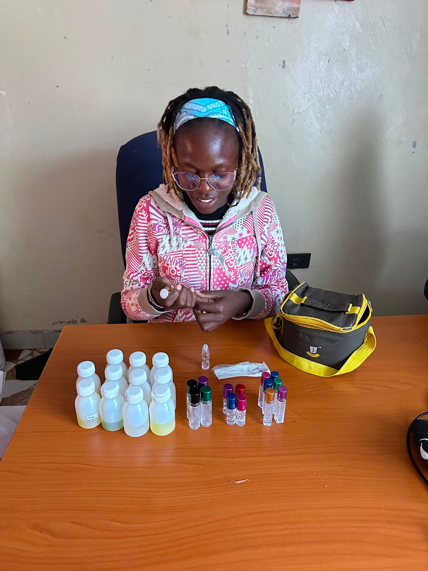 A young woman preparing bottles for the perfume business she runs.
