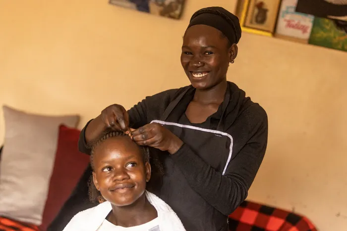 Yvonne at work in a hair and beauty salon, building the career she trained for.